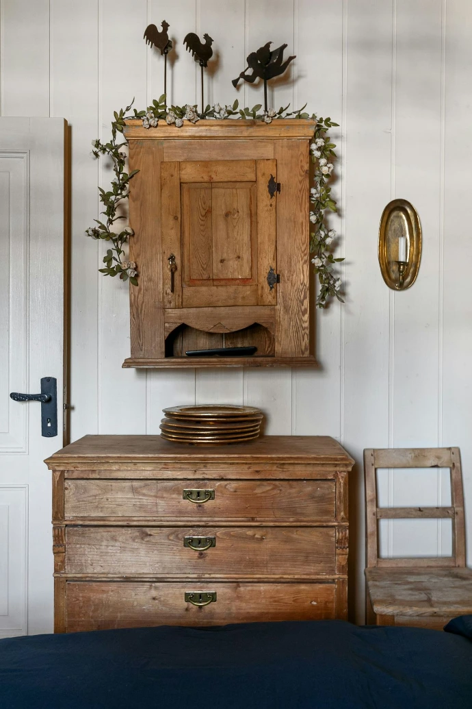 A wooden dresser sitting next to a bed in a bedroom